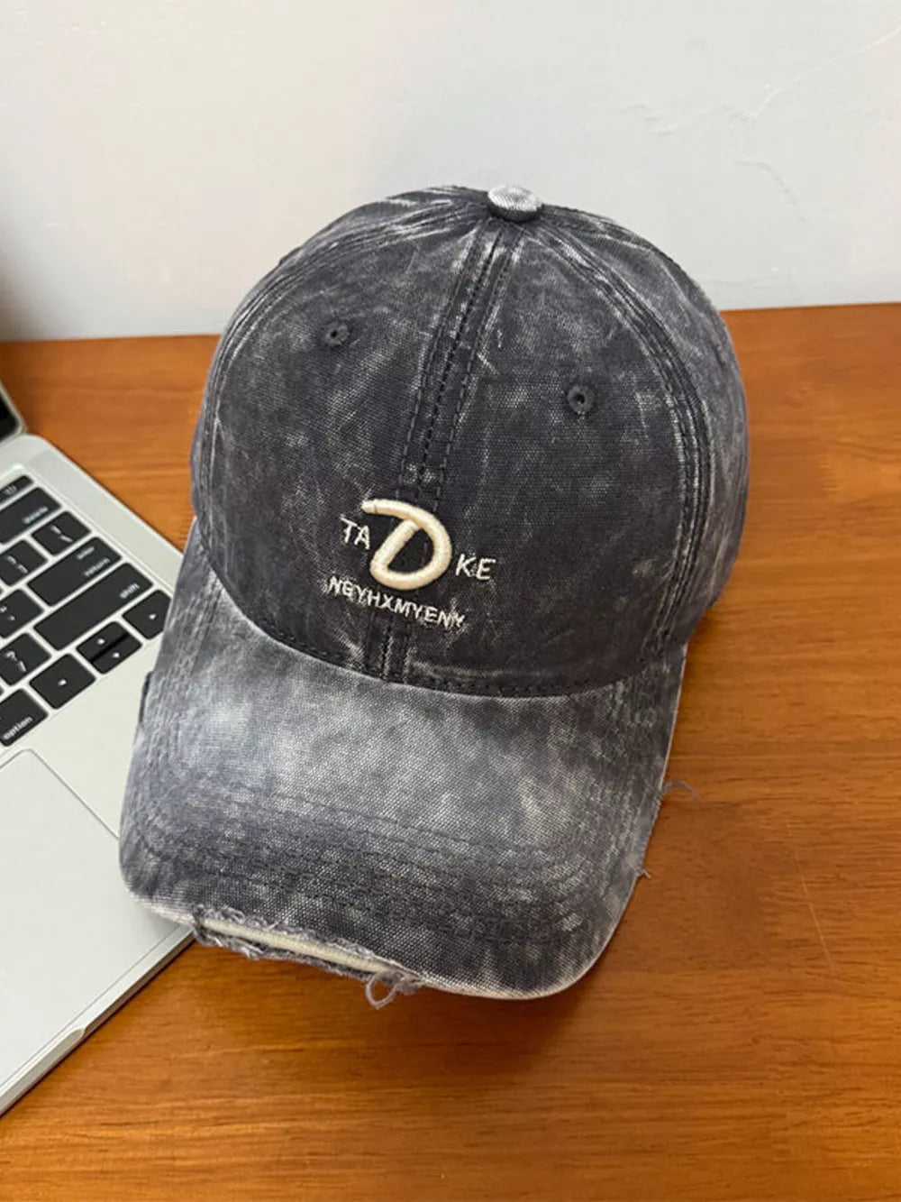 Dark Gray distressed denim baseball cap with embroidered "TA D KE" detail and frayed brim.