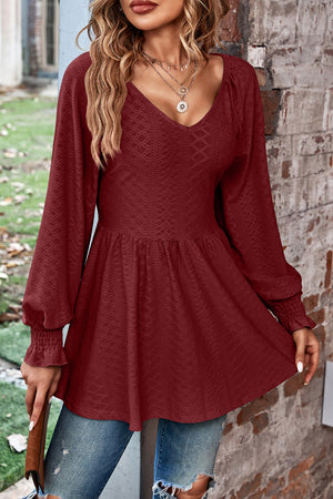 Burgundy textured blouse with V-neck, empire waist, and shirred sleeves.