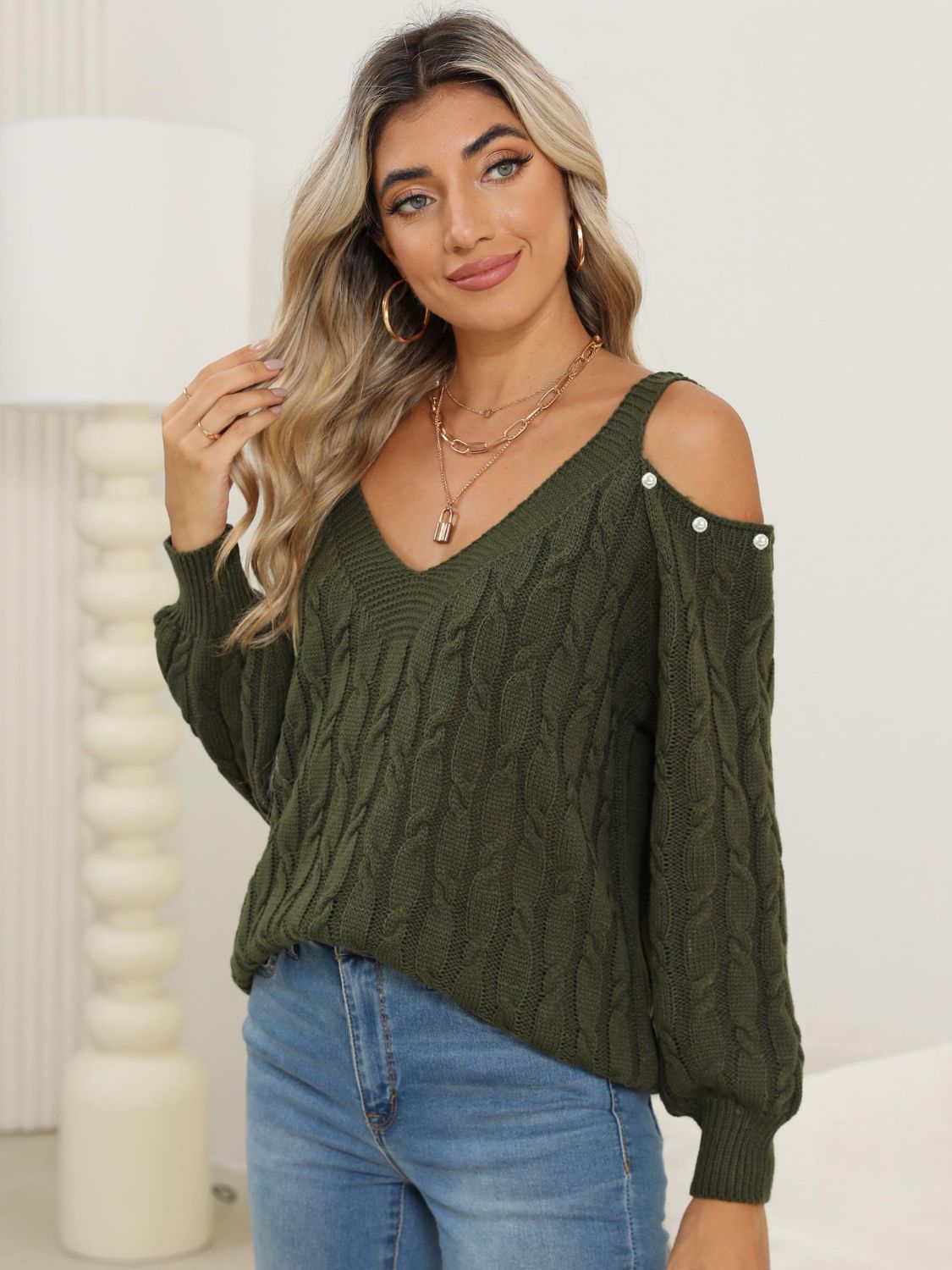 Army green cable knit sweater with cold shoulder detail and button accents.