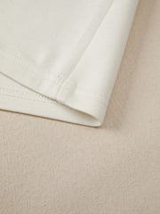 Beige buttoned blouse detail showing hem and stitching