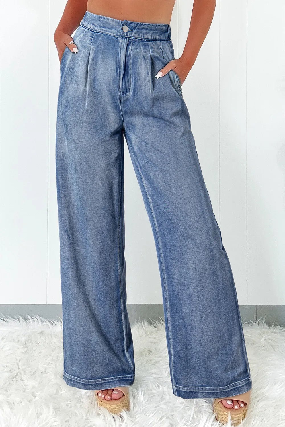 Pleated waist palazzo denim trousers in medium wash, with a wide leg cut.