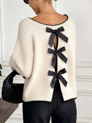 Cream knit sweater with black bowknot back detail and trim.