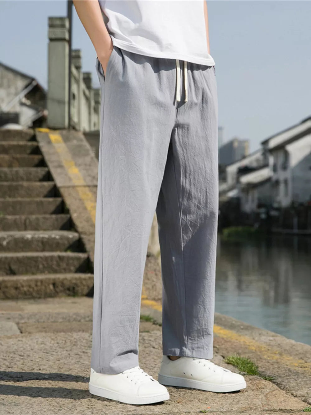 Men's light gray drawstring sweatpants with a relaxed fit.