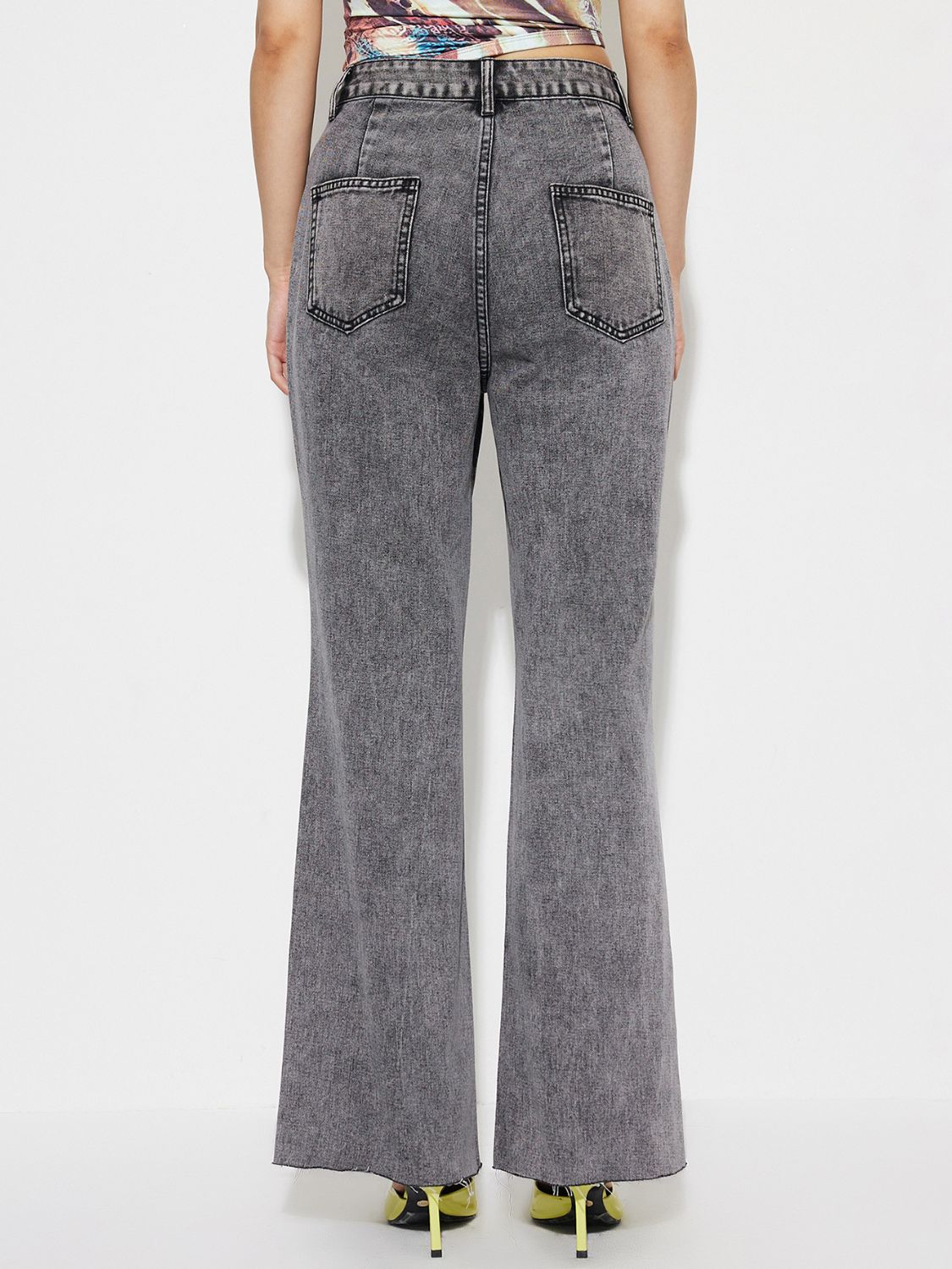 Dark gray acid wash flare jeans with a high-rise fit and raw hem.