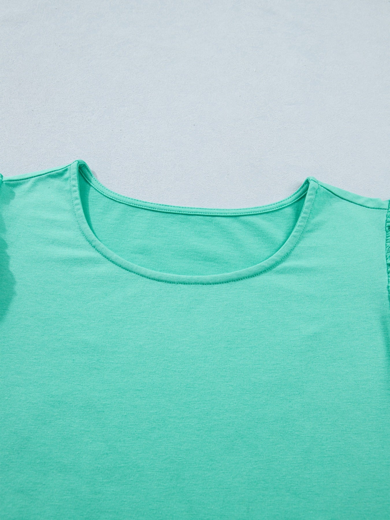 Eyelet lace ruffled cap sleeve top in mint green with a scoop neckline.