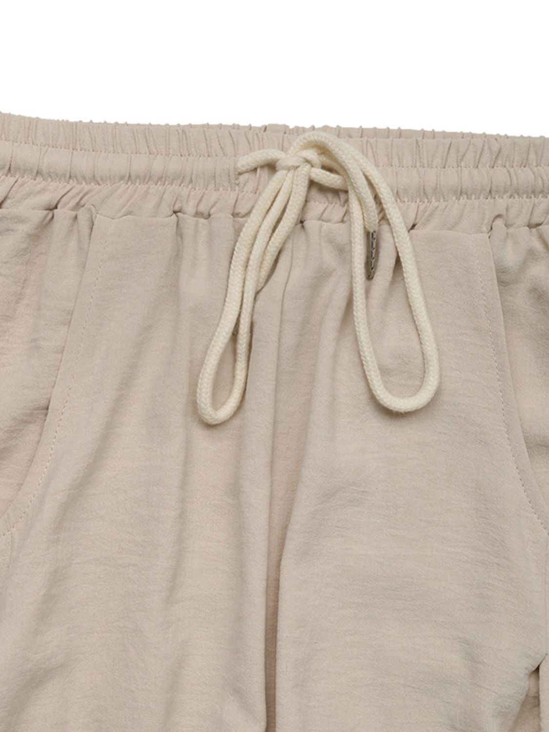 Tan palazzo trousers with drawstring waist and pockets.