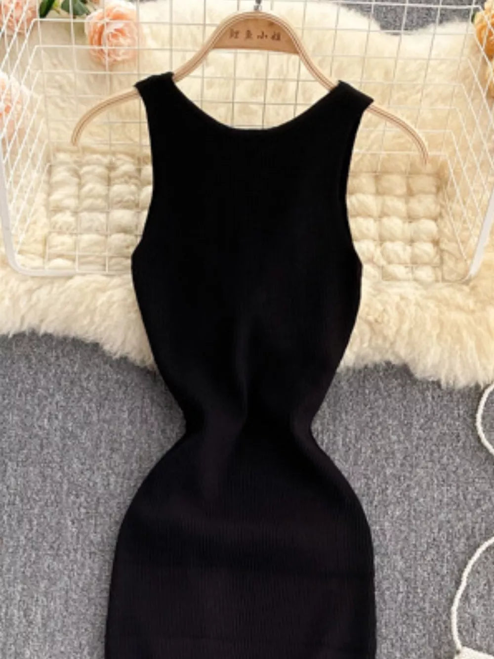 Black ribbed knit bodycon midi dress with a scoop neckline and sleeveless design.