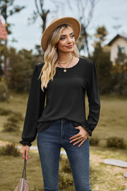 Black waffle knit blouse with perforated yoke and ruffled cuffs