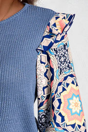 Dusty blue knit top with ruffled printed sleeves and a boho pattern.