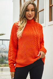 Orange cable-knit turtleneck sweater with voluminous silhouette and textured acrylic knit.