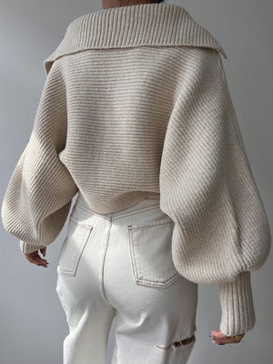 Cream knit sweater with wide collar and balloon sleeves, shown from the back.