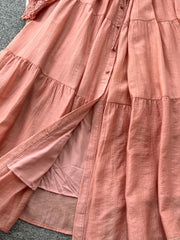 Textured tiered long sleeve dress in burnt coral with button-down front and tie waist.