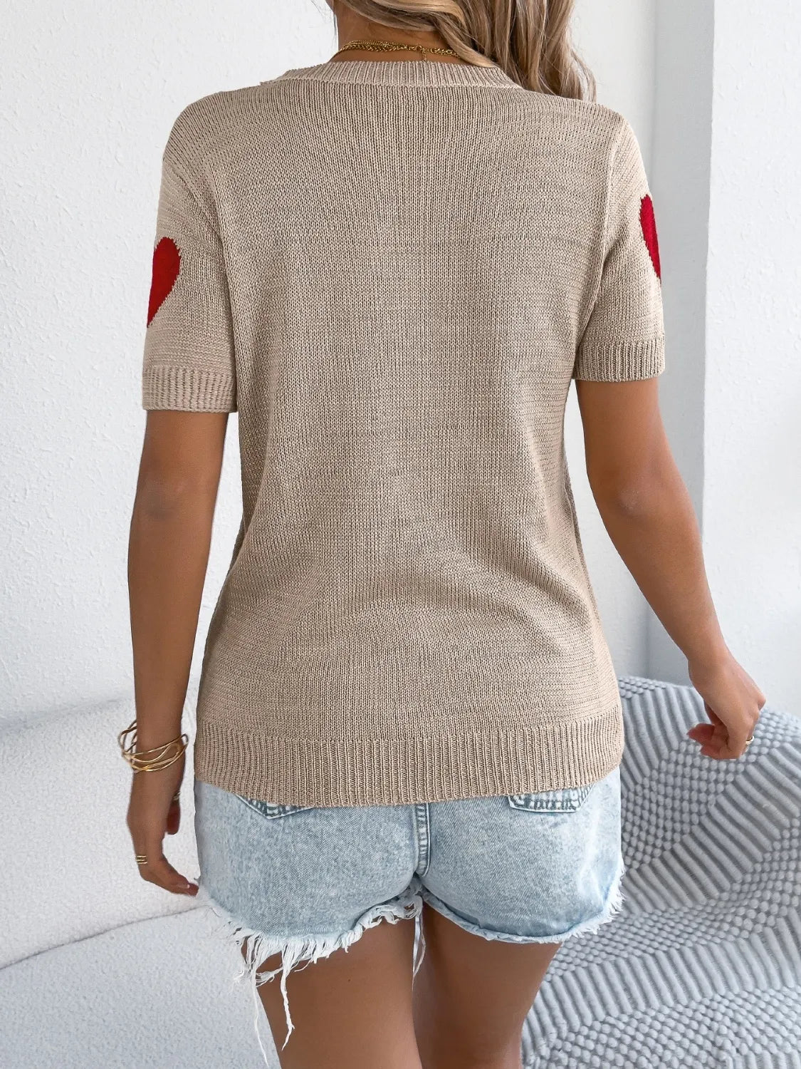 Tan knit t-shirt with red heart details on sleeves.