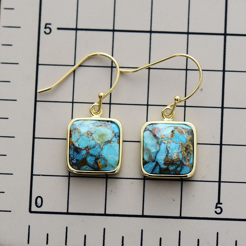 Turquoise matrix square drop earrings with gold hooks and bezel setting.