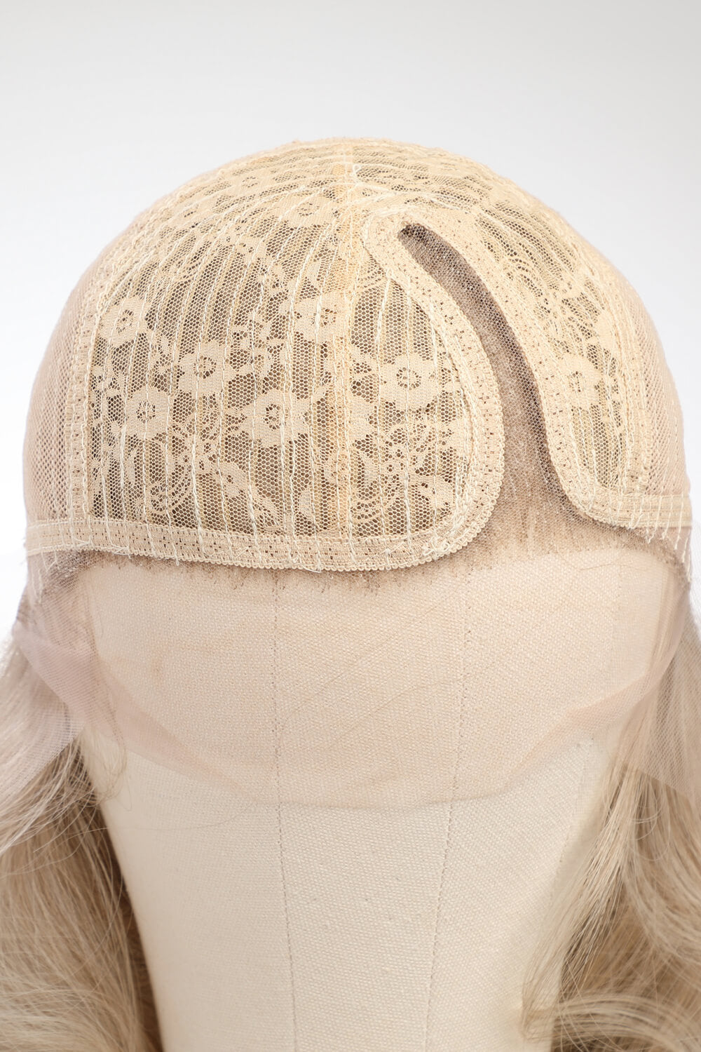 Blonde lace front wig cap with detailed floral lace overlay and mesh construction.