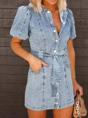 Belted denim mini dress in medium wash with puff sleeves and button front.