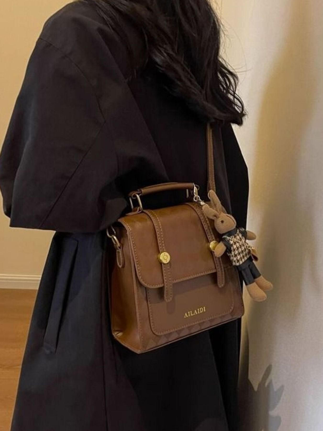 Brown quilted flap mini backpack with gold hardware and bunny charm