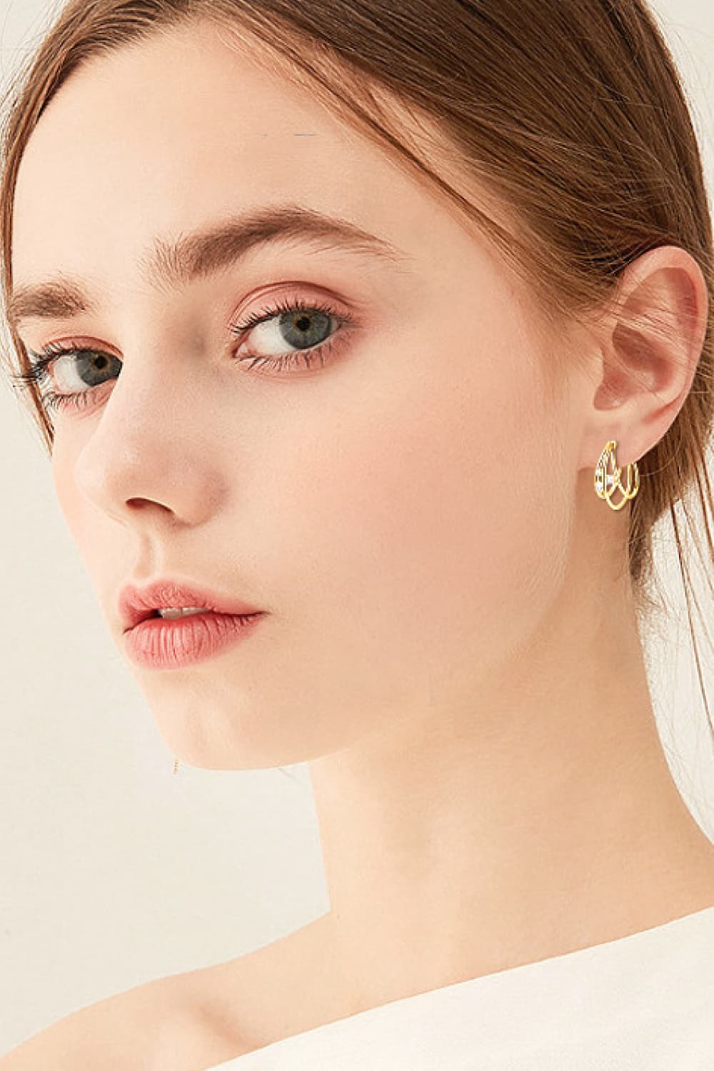 Gold hoop earrings with sculptural design and diamond accents.