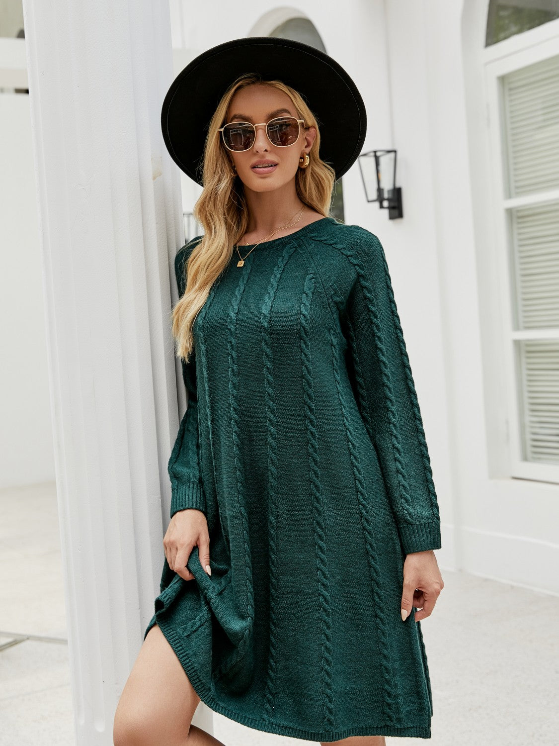 Green cable knit A-line sweater dress with long sleeves and crew neck.
