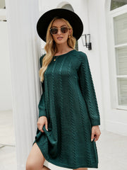 Green cable knit A-line sweater dress with long sleeves and crew neck.