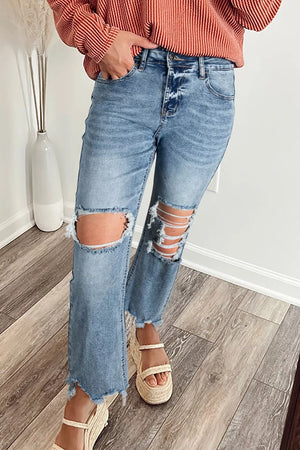Distressed open knee flare jeans in light wash denim with frayed hem and ankles.