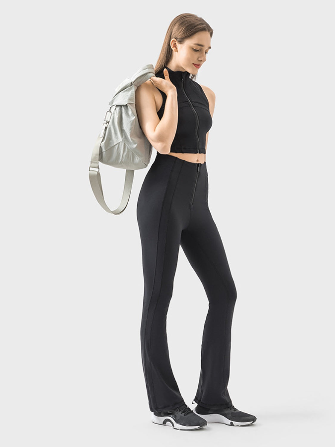 Black flared active trousers with a zip front and seam detail.