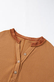 Caramel waffle knit henley top with contrast stitching and button placket.