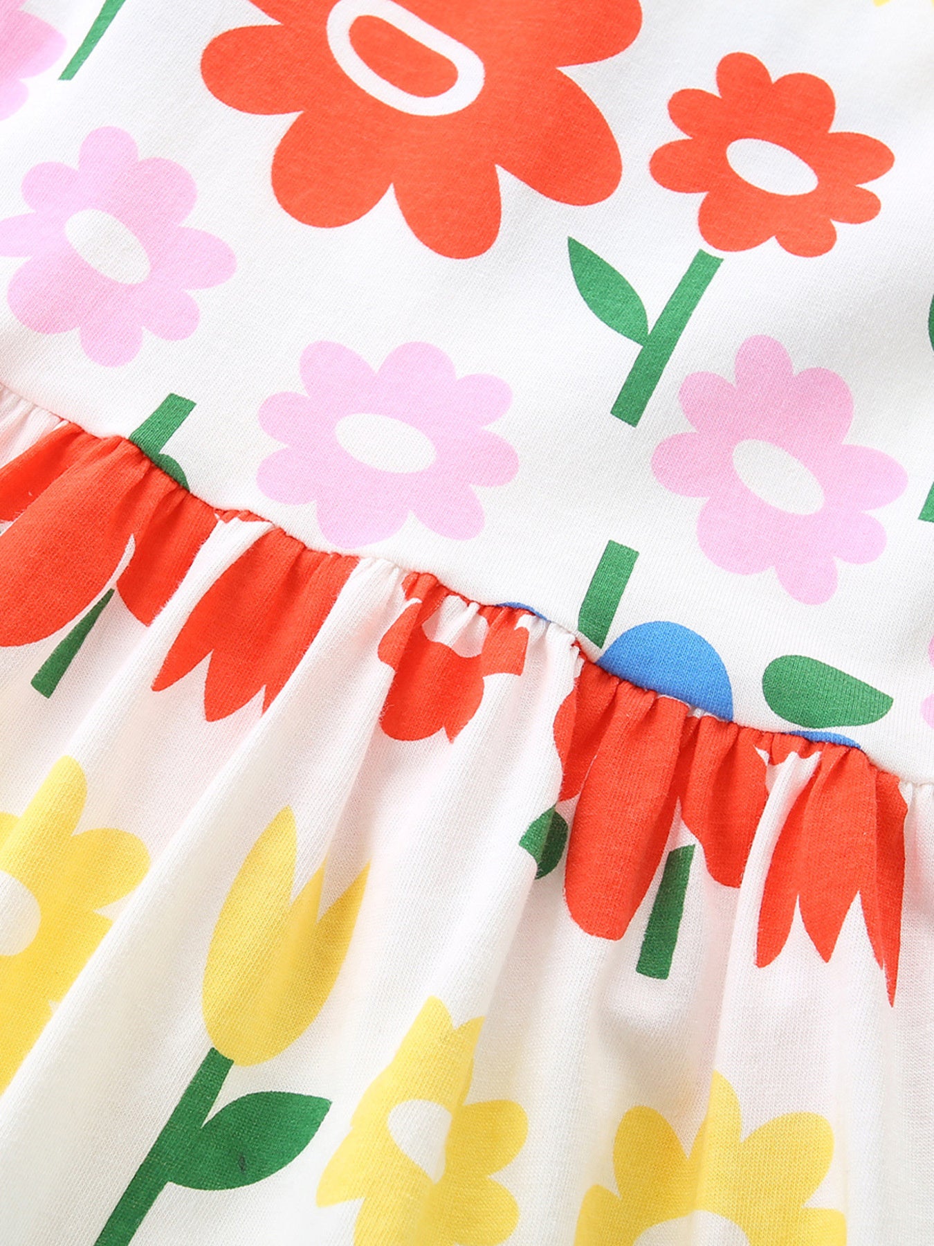 Toddler cotton dress with a white background and a colorful floral print featuring red, pink, and yellow flowers.