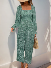 Turquoise floral jumpsuit with square neckline, smocked waist, and long sleeves.