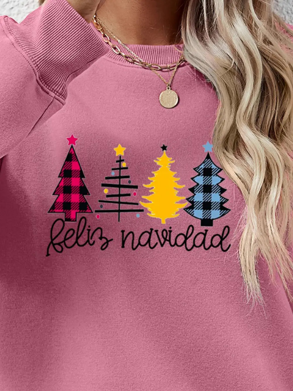 Feliz Navidad graphic crewneck sweatshirt in Blush Pink with festive Christmas trees and script text.