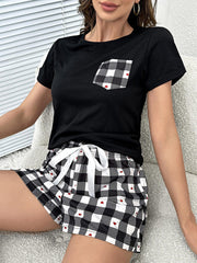 Black loungewear set with gingham shorts featuring red hearts and a matching gingham pocket detail.
