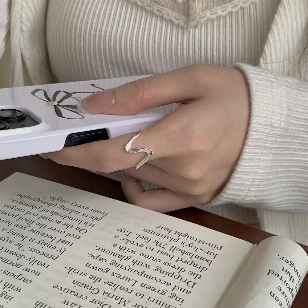 Wavy minimalist sterling silver ring with a fluid design.