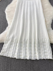 White knit midi dress with textured pattern and pearl-embellished cutout hem detail.