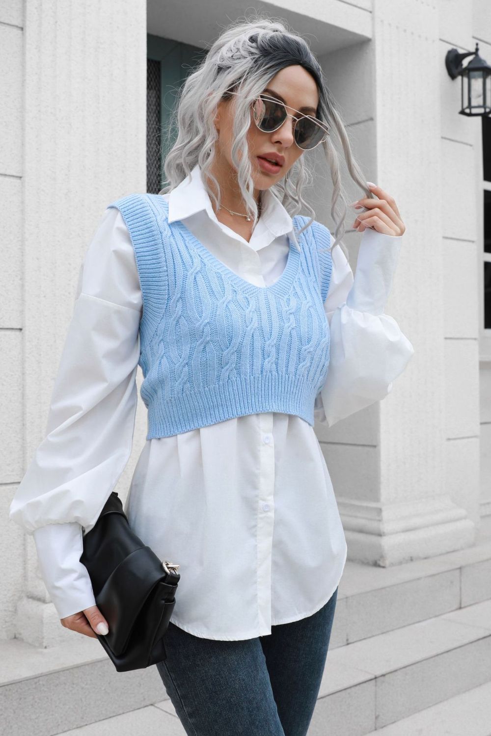 Light blue cropped cable knit v-neck vest over a white button-down shirt.