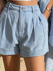 Light blue denim shorts with pleats and cuffed hems, part of a button-up shirt and shorts set.