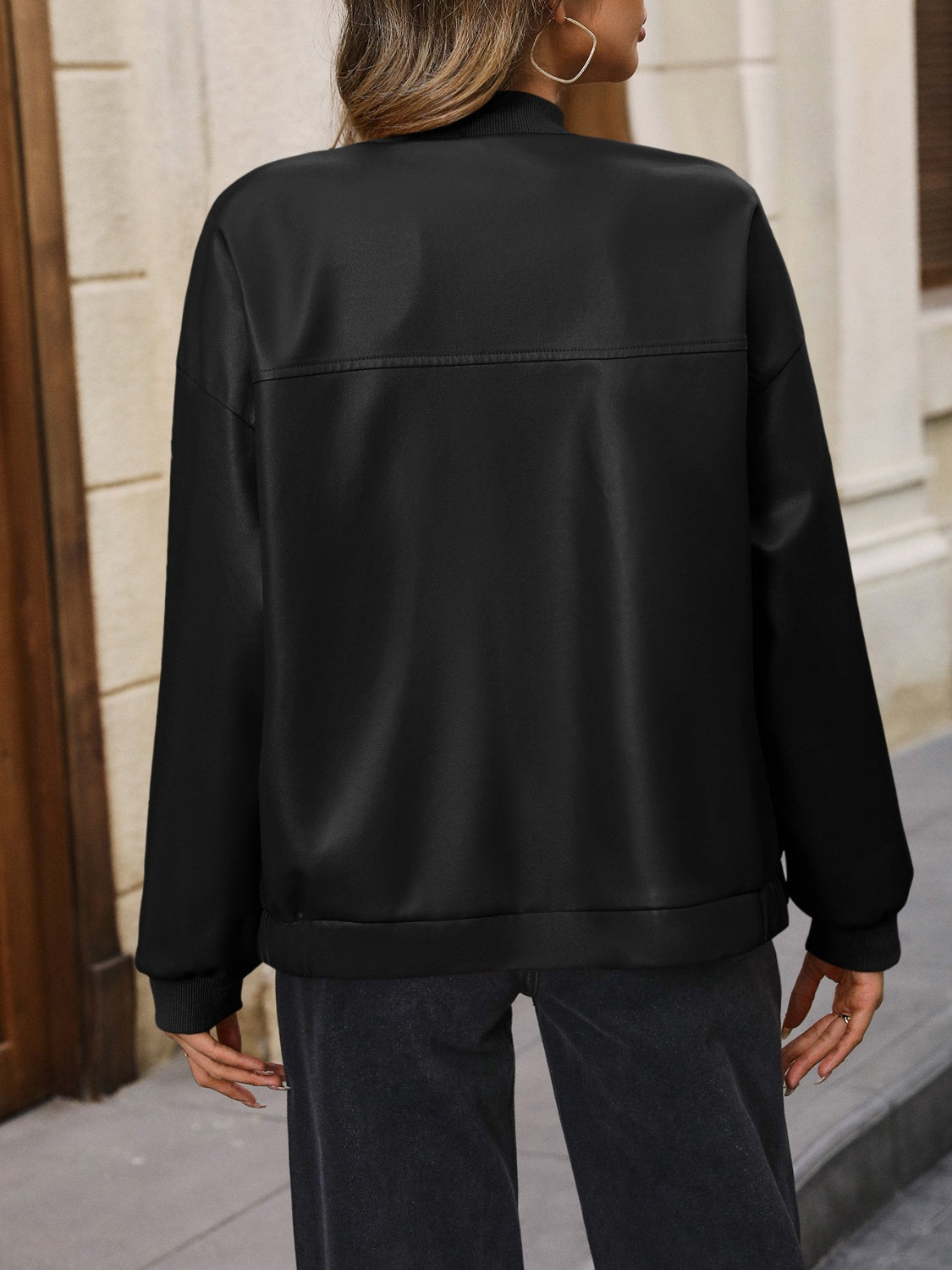 Black bomber jacket with a zip-up front and ribbed cuffs.