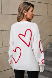 White acrylic knit jumper with red heart outline pattern, crew neck, long sleeves.