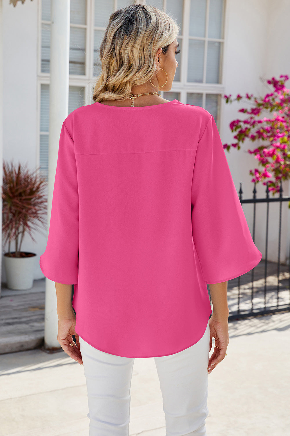 Hot pink flow blouse with asymmetric bell sleeves and a casual cut.