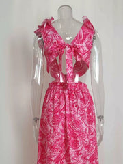 Pink paisley print V-neck maxi dress with ruffled shoulders and cut-out sides.