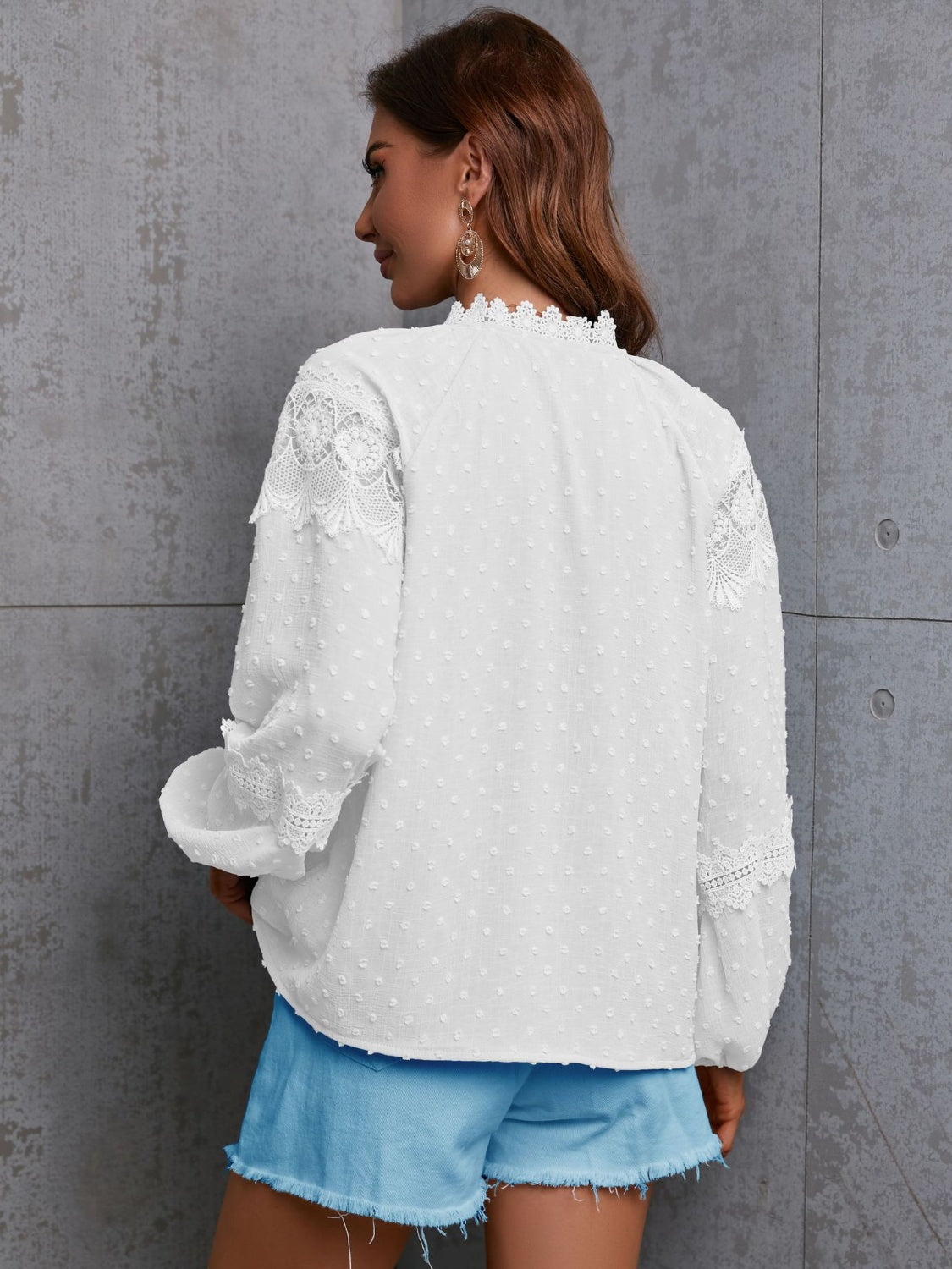 White textured blouse with lace trim on neckline and sleeves.