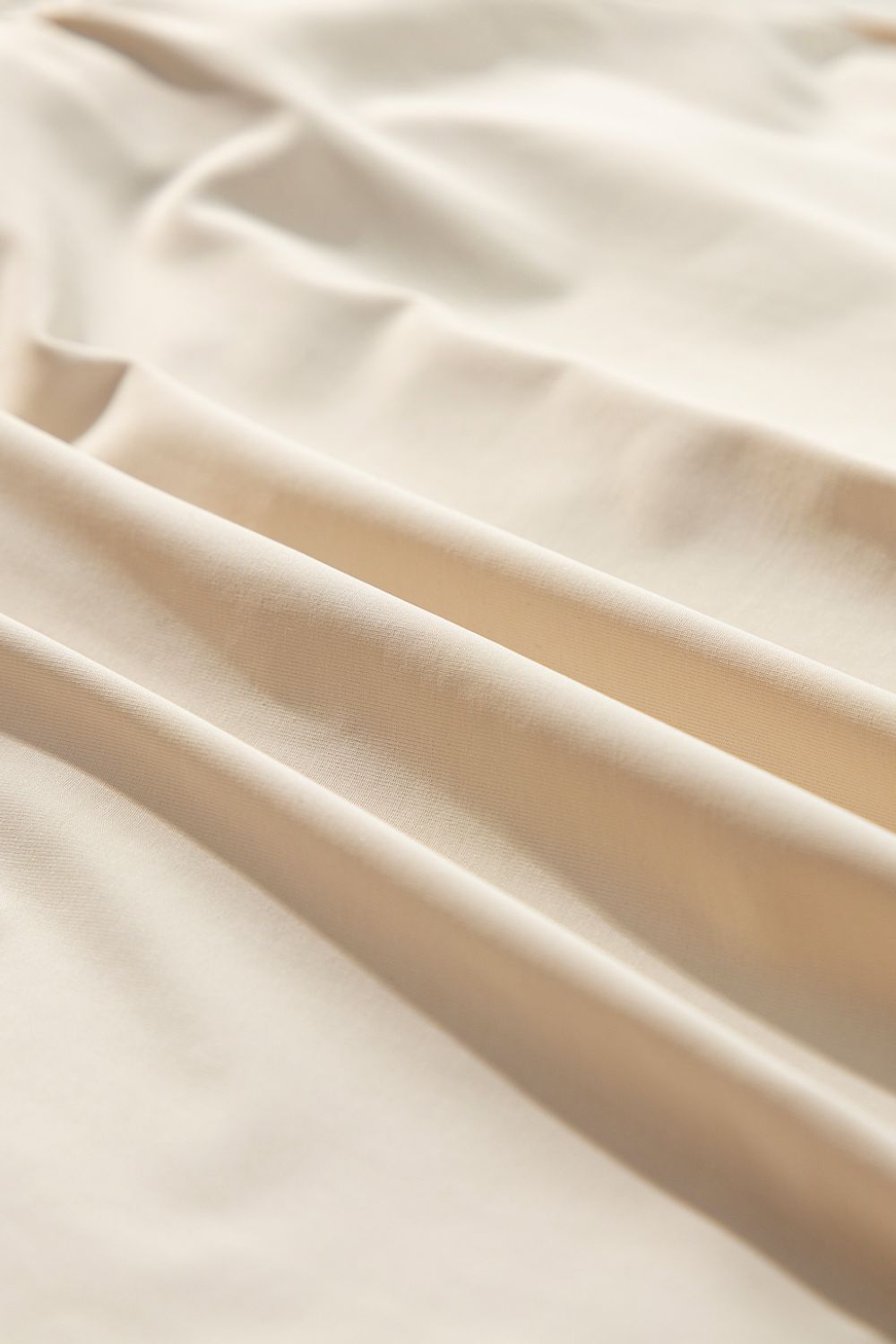 Beige ruffled skort with tie waist detail, close-up fabric texture.