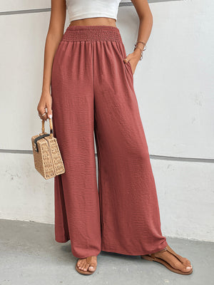 Textured palazzo lounge trousers in rust with a smocked waistband and wide legs.