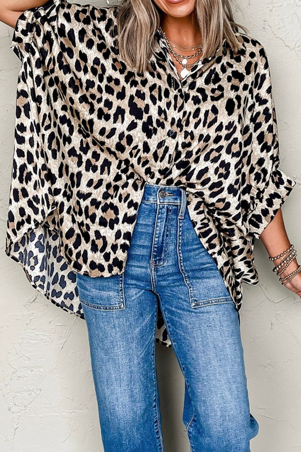 Leopard print oversized button-down blouse with ruffled sleeves, styled with jeans.