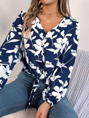 Navy floral knot-front blouse with button detail and ruffled cuffs.