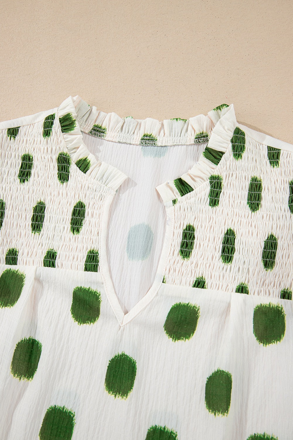 Textured polka dot blouse in matcha green with smocked yoke and v-neck.