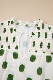 Textured polka dot blouse in matcha green with smocked yoke and v-neck.