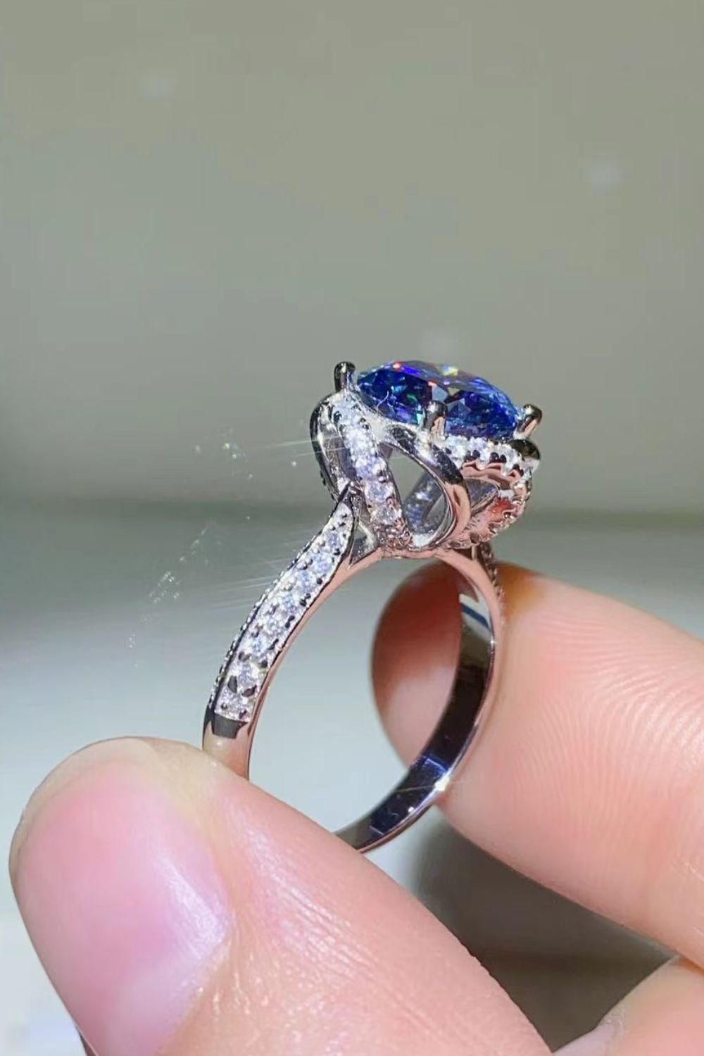 Blue moissanite halo ring with diamond band and silver setting