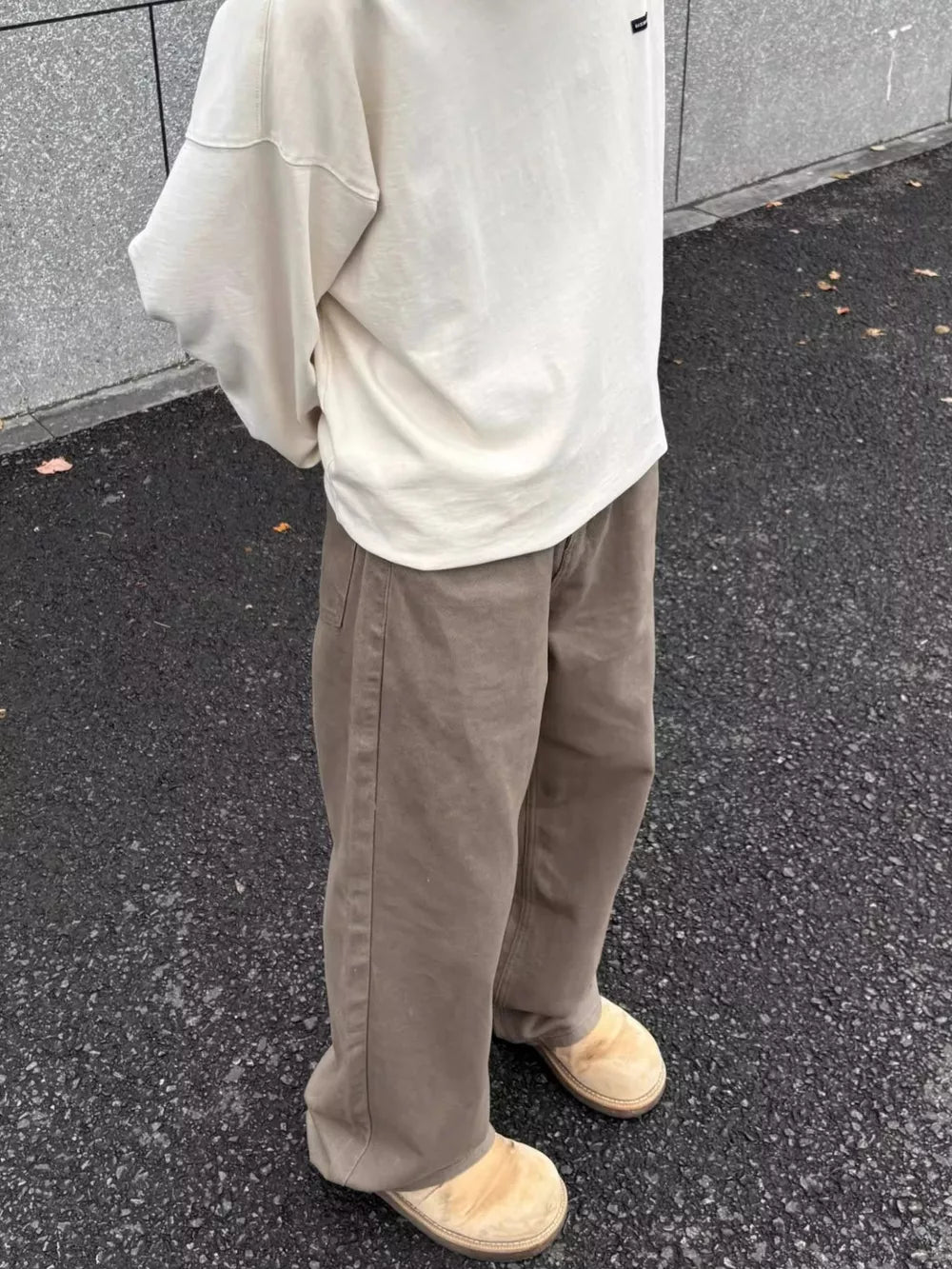 Men's brown wide-leg sweatpants with a relaxed fit and visible stitching.
