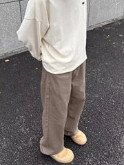 Men's brown wide-leg sweatpants with a relaxed fit and visible stitching.