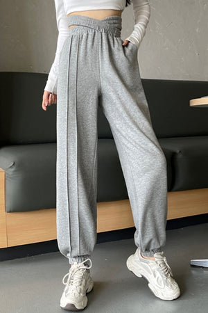 Gray Dawn pleated waistline joggers with pockets and elastic cuffs.